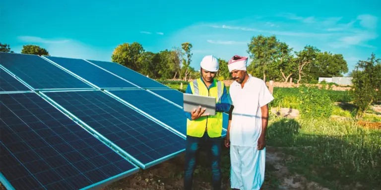 Solar energy professionals beside installed panels