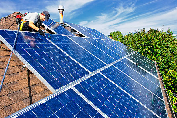 Technicians installing solar panels on a rooftop